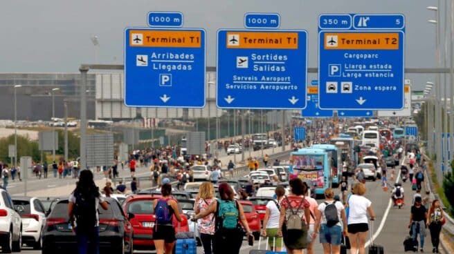 Pasajeros acceden a pie al aeropuerto de El Prat por el corte de los accesos por manifestantes independentistas. Pasajeros acceden a pie al aeropuerto de El Prat por el corte de los accesos por manifestantes independentistas.