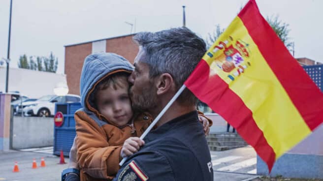 Un policía nacional besa a su hijo a su regreso a Madrid, este martes, tras intervenir en el refuerzo en Cataluña.