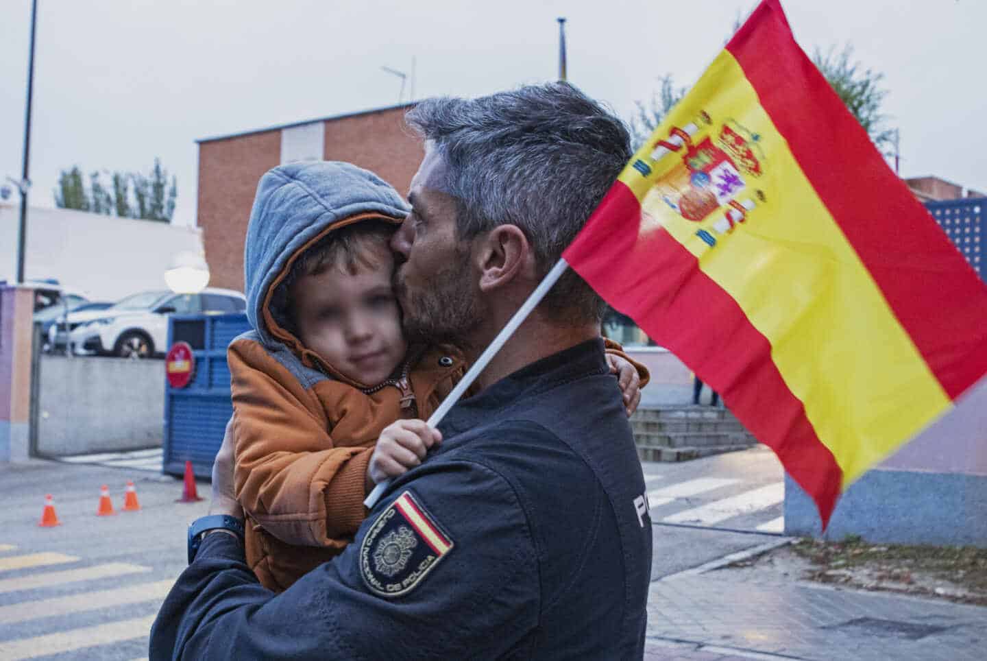 Un policía nacional besa a su hijo a su regreso a Madrid, este martes, tras intervenir en el refuerzo en Cataluña.