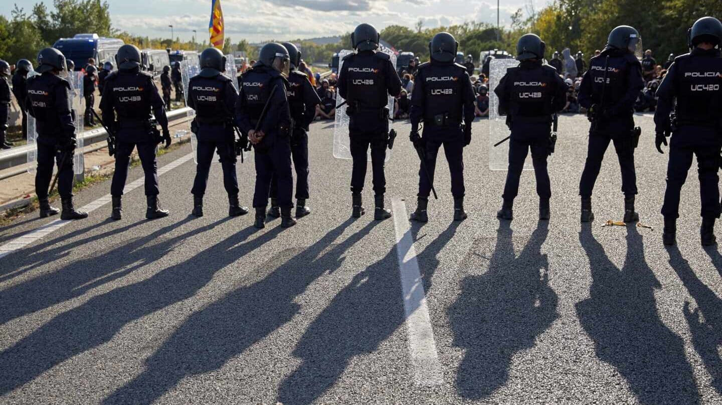Policías nacionales, desalojando a los manifestantes que cortaban el tráfico en la AP-7 en Girona.