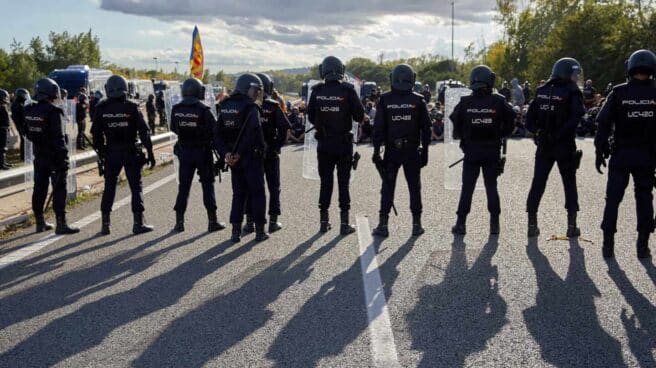 Policías nacionales, desalojando a los manifestantes que cortaban el tráfico en la AP-7 en Girona.