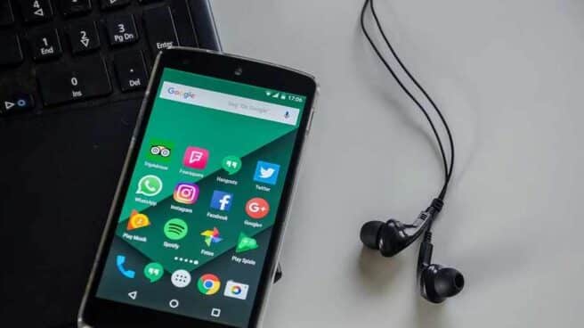 Un ordenador, un móvil y unos auriculares.