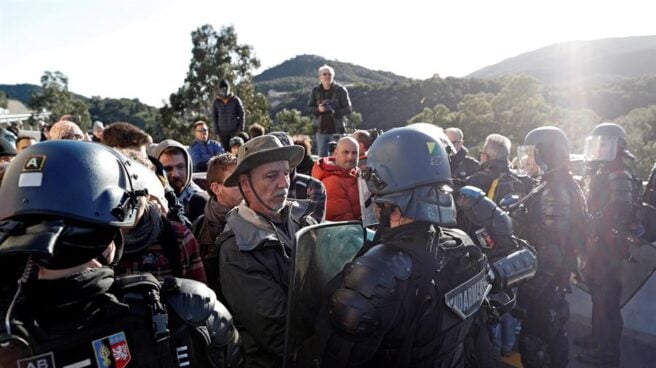 Gendarmes franceses tratan de desbloquear el corte de la autopista que enlaza España y Francia en el paso de Le Perthus (Francia).