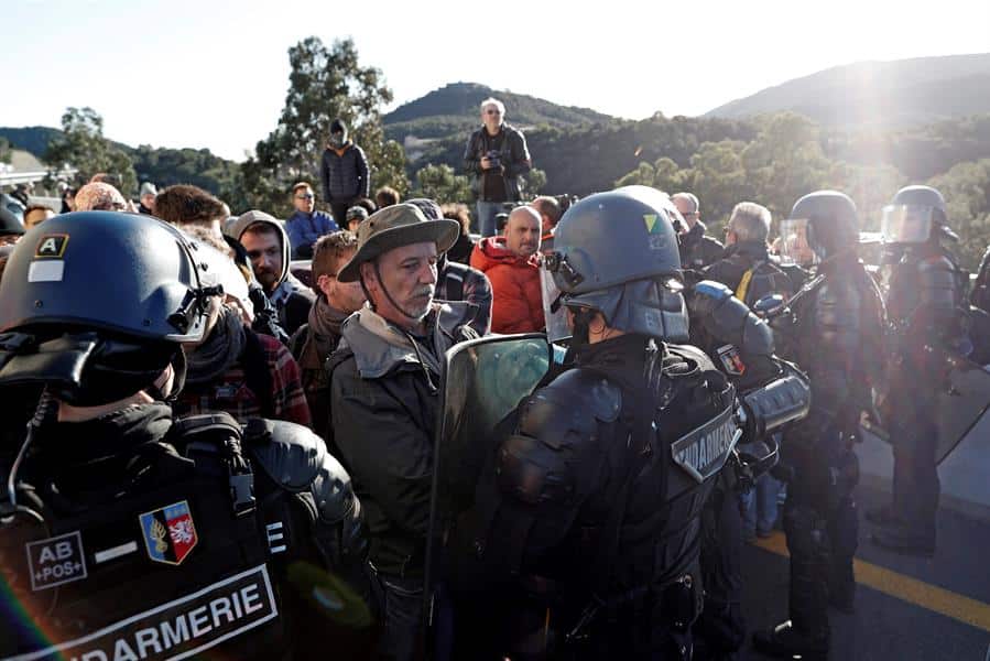Gendarmes franceses tratan de desbloquear el corte de la autopista que enlaza España y Francia en el paso de Le Perthus (Francia).