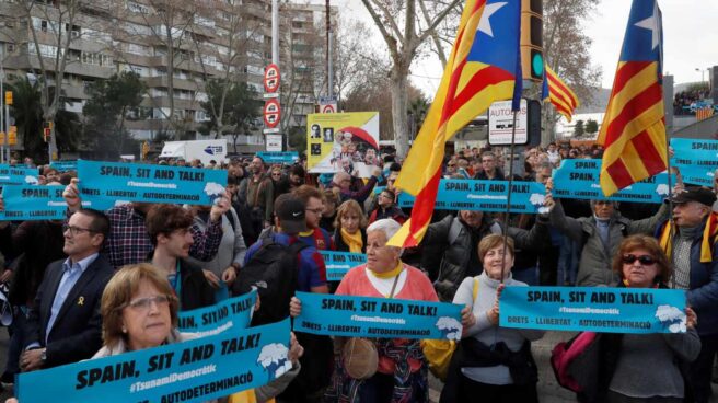Varias personas sostienen pancartas de "Tsunami Democràtic" en los aledaños del Camp Nou.
