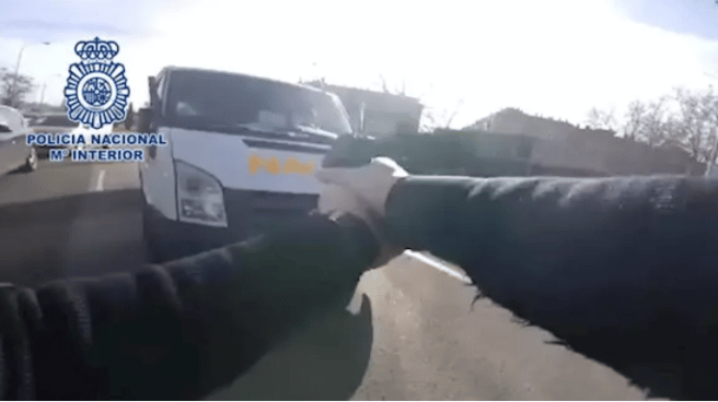 Agente de la Policía Nacional apuntando a una furgoneta.