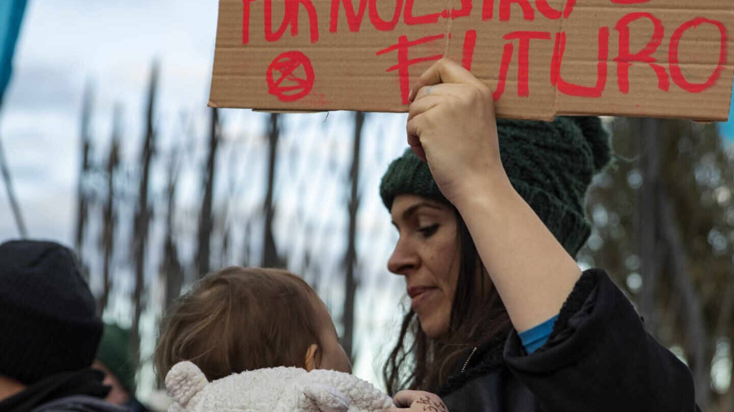 Una mujer protesta en la puerta de la Cumbre del Clima con un bebé en brazos