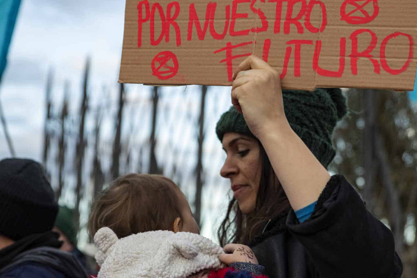 Una mujer protesta en la puerta de la Cumbre del Clima con un bebé en brazos