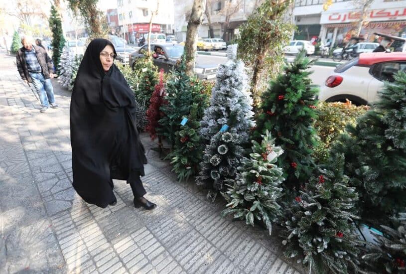 Unos 150.000 cristianos viven en inmensa minoría en Irán. En la imagen, una mujer camina en Teherán frente a una tienda que vende elementos decorativos para las fiestas navideñas.