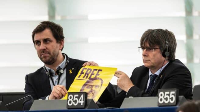 Toni Comín y Carles Puigdemont sujetando un cartel por la libertad de Oriol Junqueras.