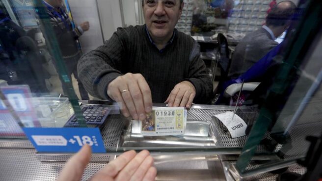 Un hombre compra un décimo de Lotería del Niño.