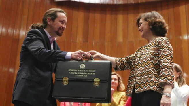 Pablo Iglesias recibe el maletín de la vicepresidencia de manos de Carmen Calvo.
