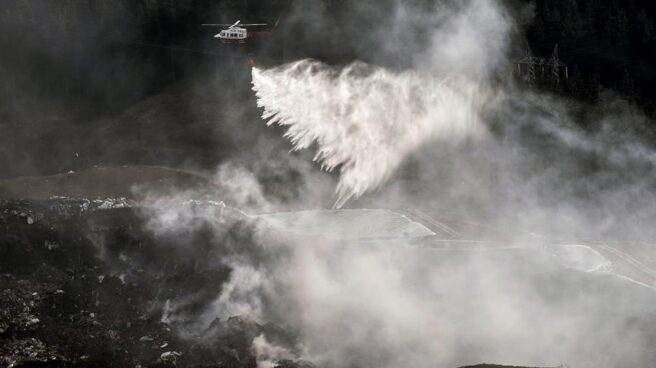 Un helicóptero arroja agua sobre un incendio ocasionado en el vertedero de Zaldibar.