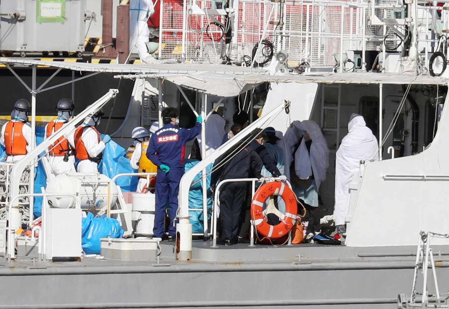 Cubiertos con sábanas blancas los pasajeros infectados a bordo del Diamond Princess en Yokohama.