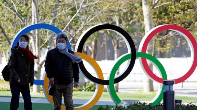 Dos personas con mascarilla caminan en la entrad del Comité Olímpico de Japón