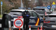 Un policía nacional se protege con una mascarilla en uno de los controles de frontera establecidos tras declararse el estado de alarma.