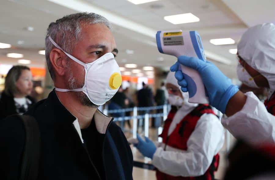 Un hombre con mascarilla pasa un control en el aeropuerto de Quito