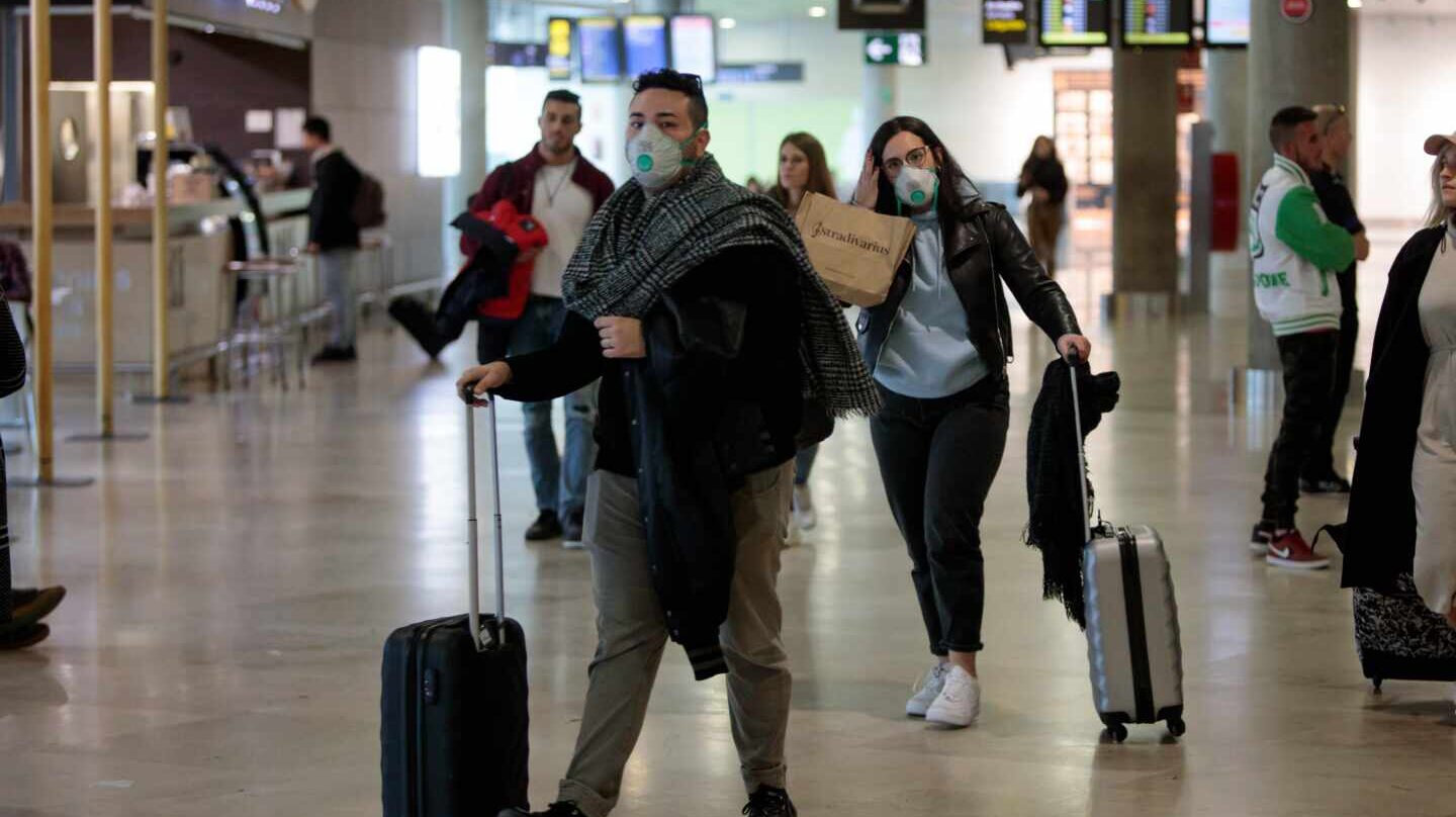 Pasajeros con mascarillas por el coronavirus en un aeropuerto.