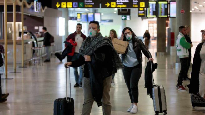 Aislado en su casa un vigilante de seguridad del aeropuerto de Barajas por coronavirus Pasajeros con mascarillas por el coronavirus en un aeropuerto.