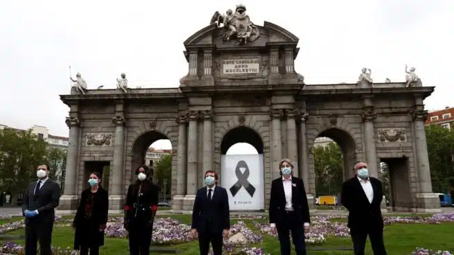 Madrid recuerda a los muertos de COVID con un crespón en la Puerta de Alcalá