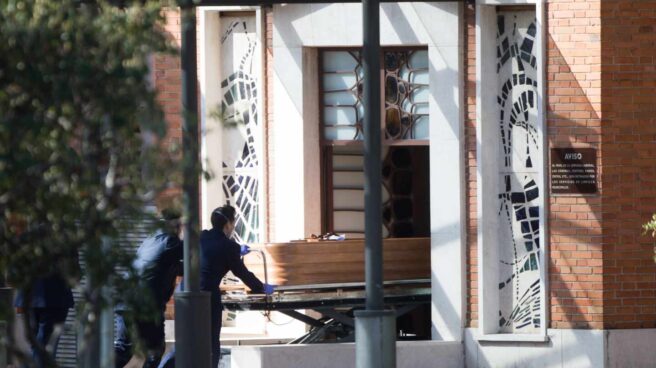 Dos trabajadores transportan un ataúd en la funeraria municipal de Madrid.