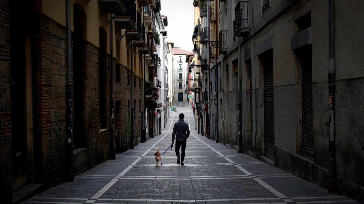 Un hombre pasea a un perro en Pamplona durante el confinamiento