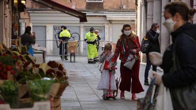 Ciudadanos en Italia acuden a un mercado de Venecia protegidos con mascarillas.