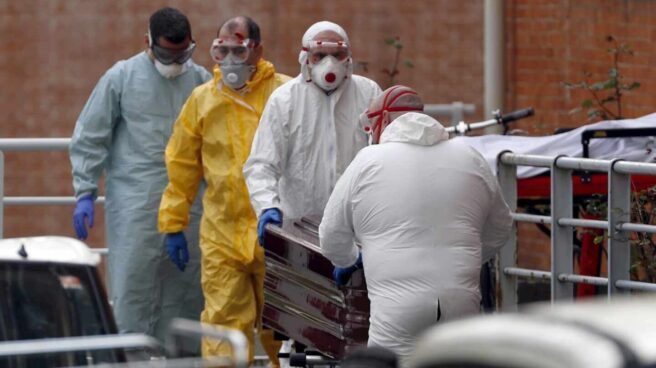 Trabajadores de una funeraria trasladan un cadáver a la morgue.