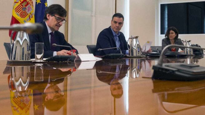 Pedro Sánchez, flanqueado por el ministro de Sanidad (Salvador Illa) y la doctora María José Sierra, en una reunión en La Moncloa.