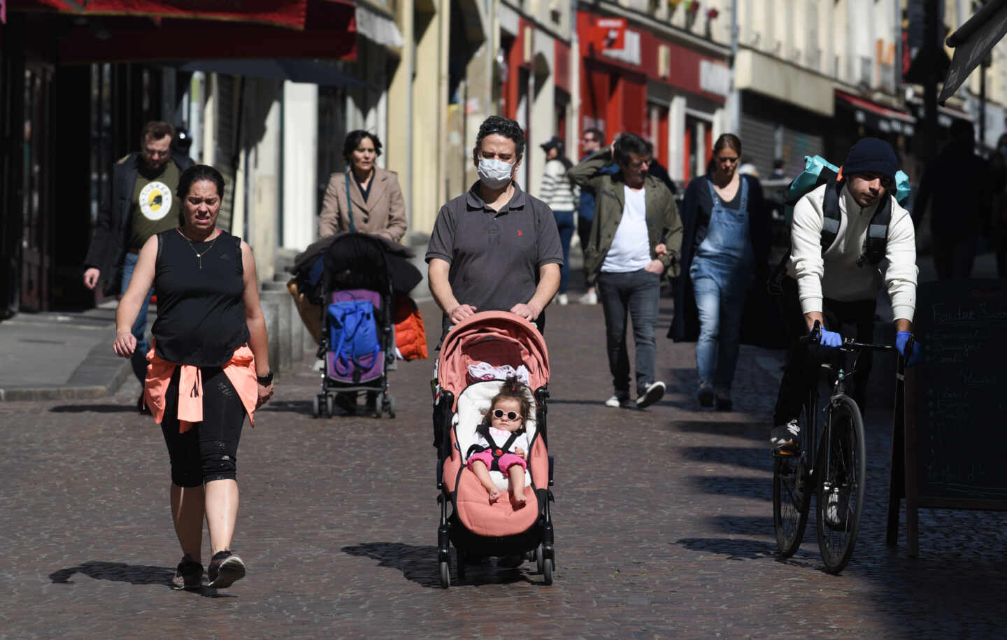 Una familia con un niño en un carrito por las calles de París a principios de este mes de abril.