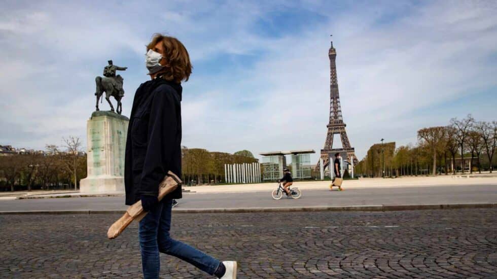 Una mujer pasa por delante de la Torre Eiffel durante el confinamiento en París