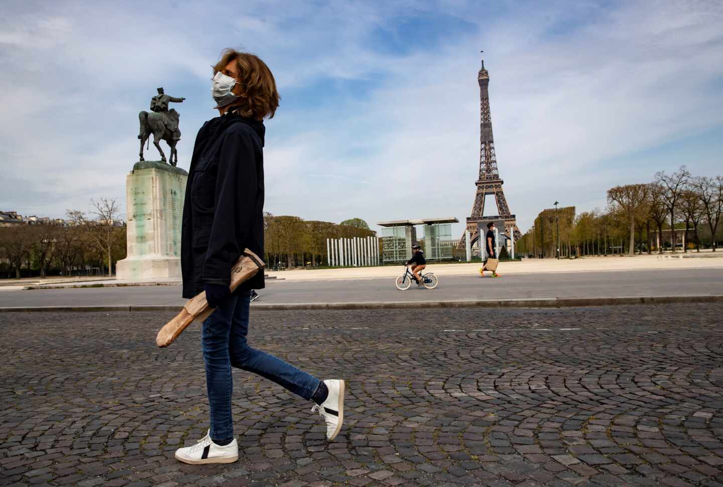 Una mujer pasa por delante de la Torre Eiffel durante el confinamiento en París