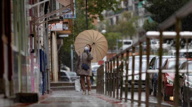 Una mujer se cubre con paraguas de las precipitaciones caídas en Madrid.