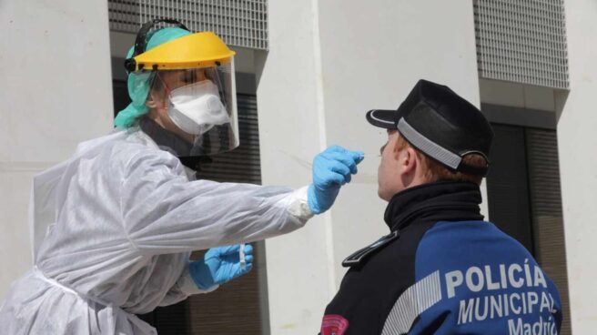 Profesionales de Madrid Salud hacen un test de detección a un agente de la Policía Municipal.