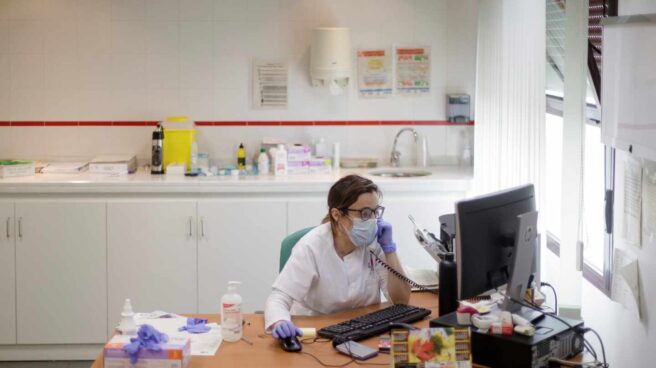 Una médica atendiendo por teléfono una consulta.