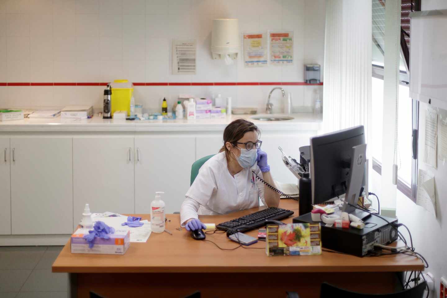 Una médica atendiendo por teléfono una consulta.