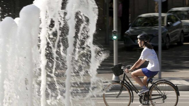 Un mujer con su bicicleta por el centro de Madrid.