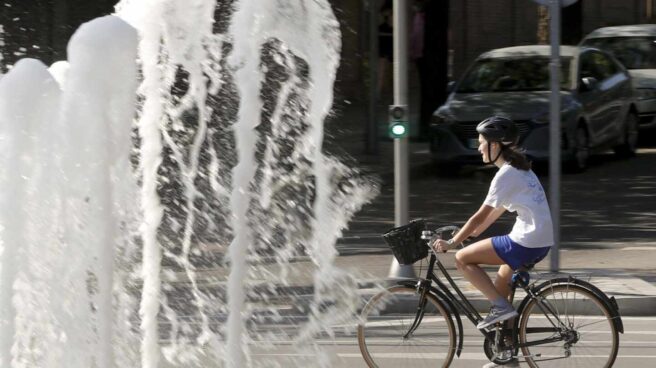 La nueva normativa para bicicletas y patinetes a partir de verano en Madrid Un mujer con su bicicleta por el centro de Madrid.