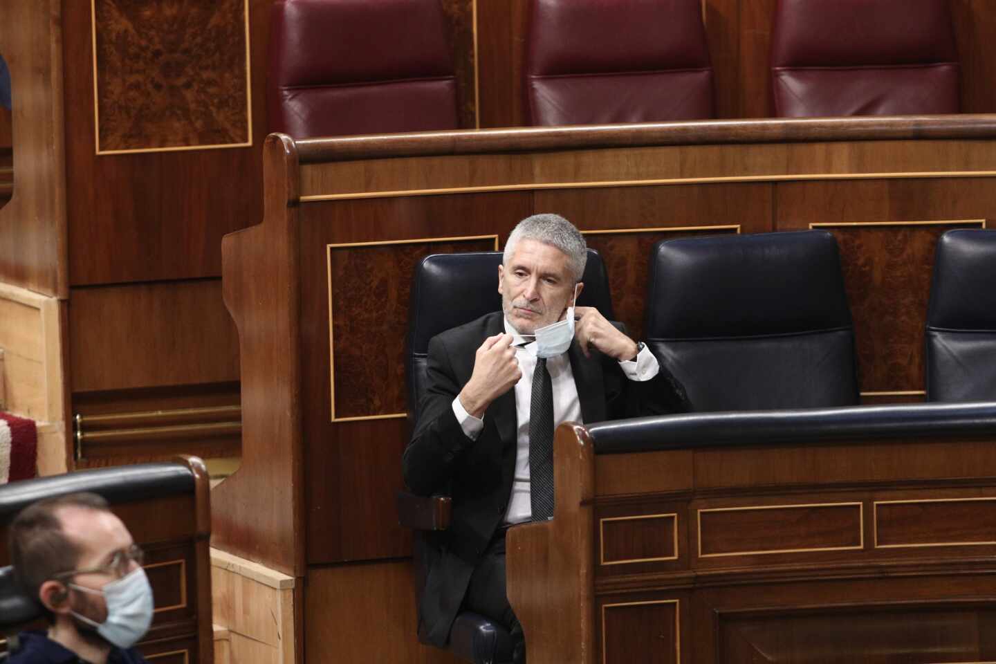 El ministro Grande-Marlaska, retirándose la mascarillas este miércoles en su escaño del Congreso de los Diputados.