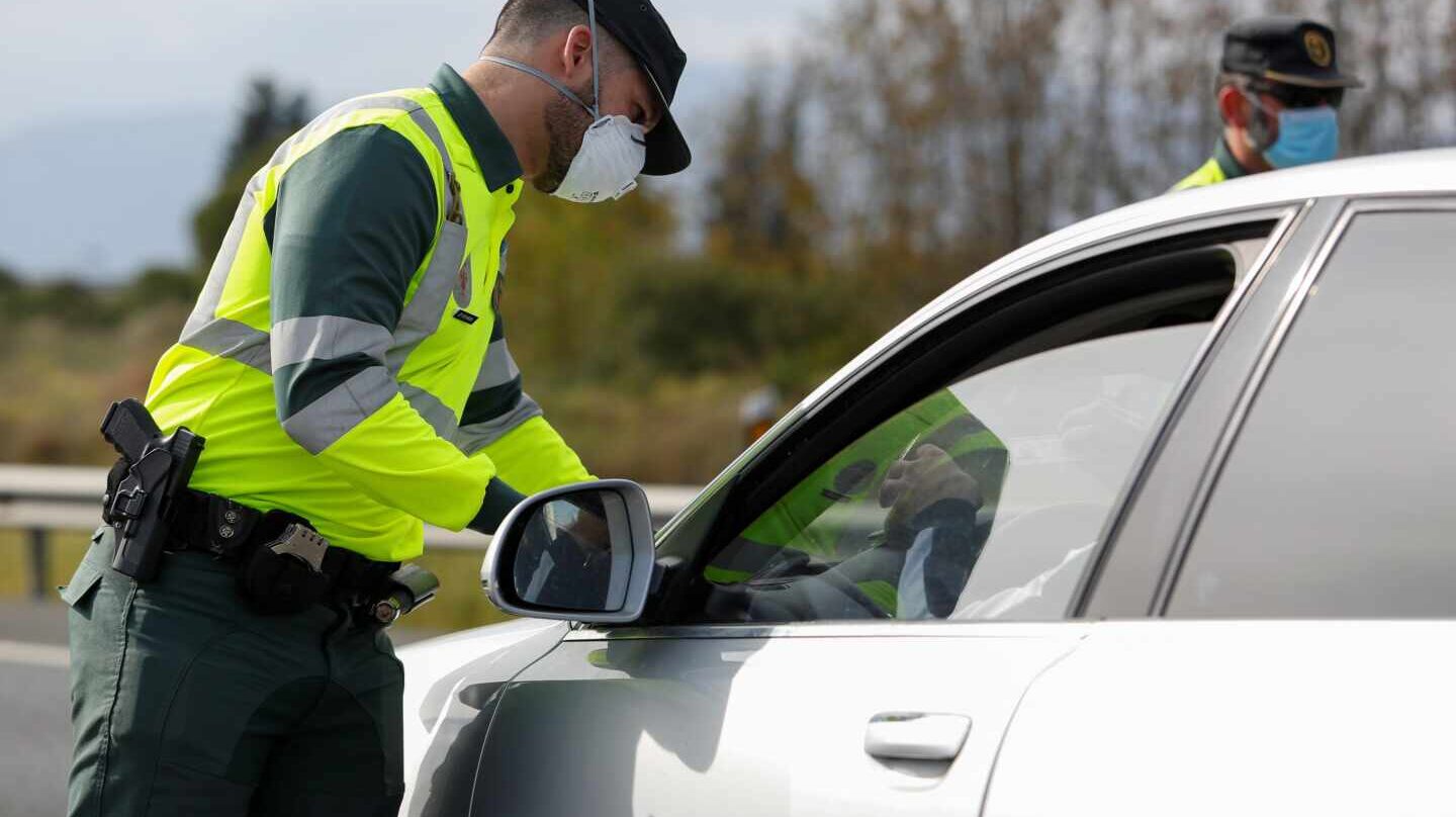 Un guardia civil, protegido con una mascarilla, durante un control de tráfico durante el estado de alarma.