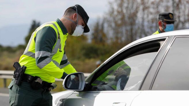 Un guardia civil, protegido con una mascarilla, durante un control de tráfico