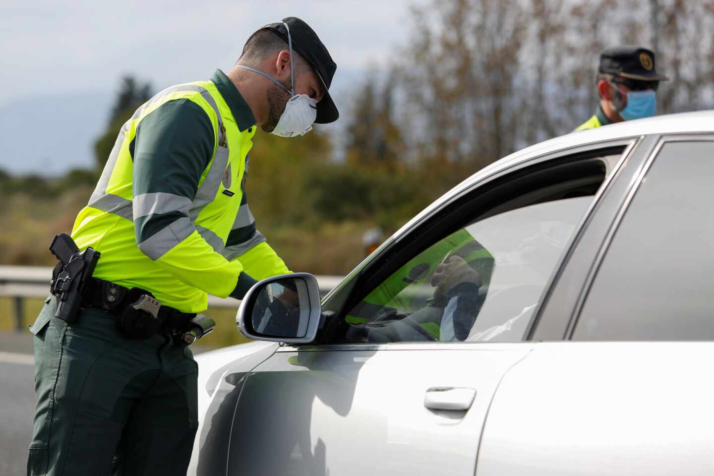 Un guardia civil, protegido con una mascarilla, durante un control de tráfico