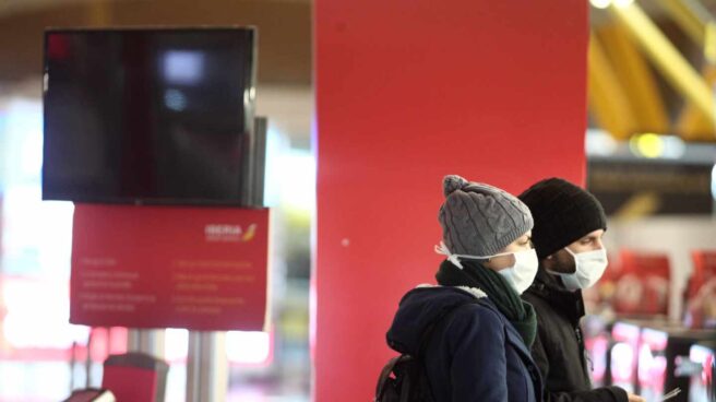 Pasajeros en el aeropuerto de Madrid-Barajas con mascarillas.