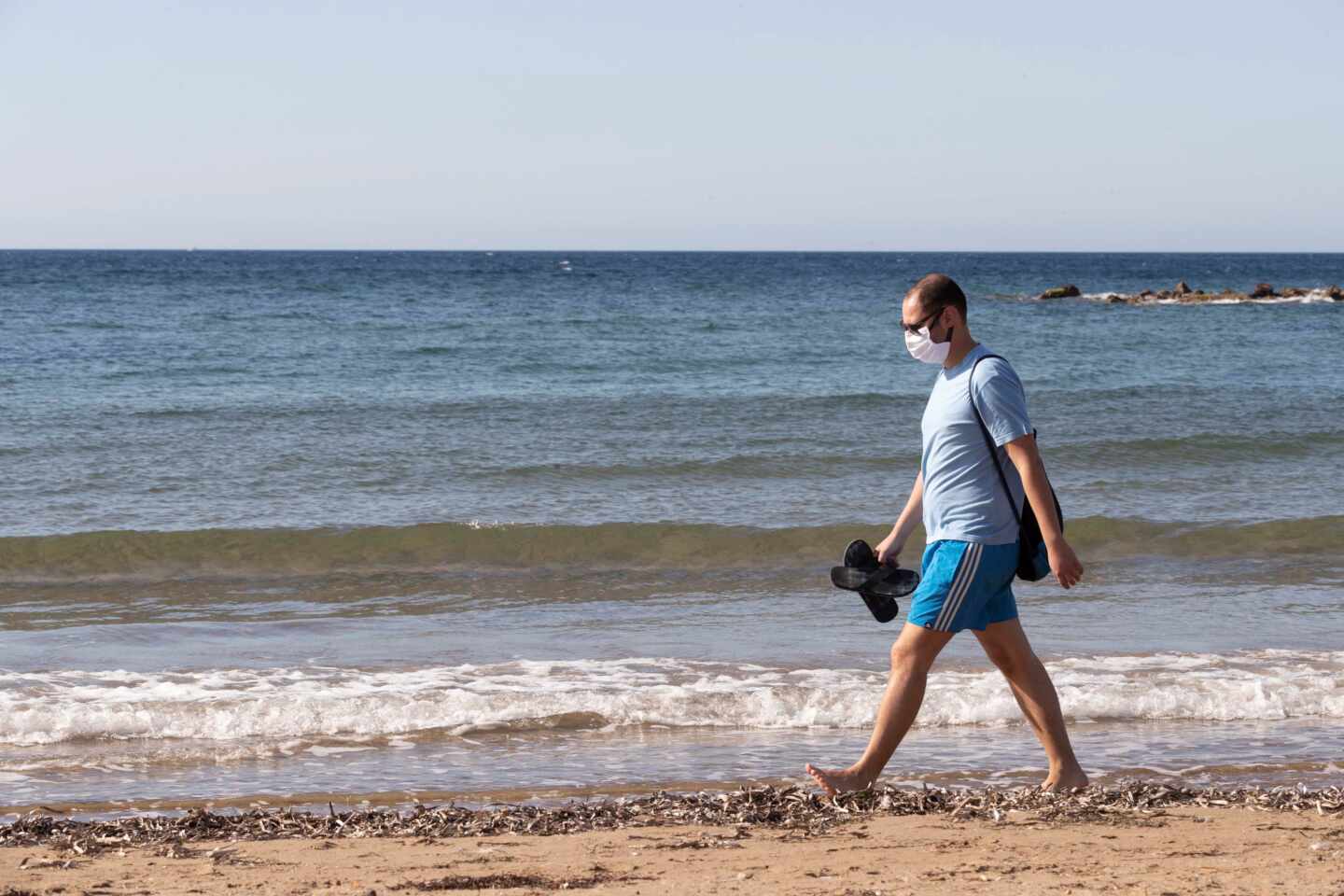 Un bañista con mascarilla en la playa de Mazarrón, en Murcia.