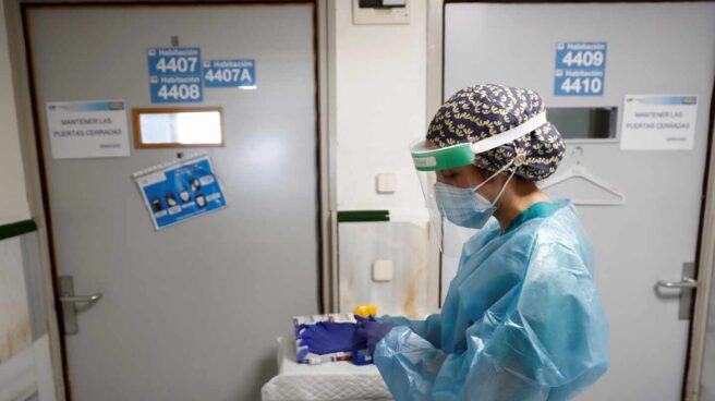 Una sanitaria se ajusta los guantes en una de las tres unidades de hospitalización con pacientes con Covid aún operativas en el área de medicina interna del Hospital Gregorio Marañón de Madrid.