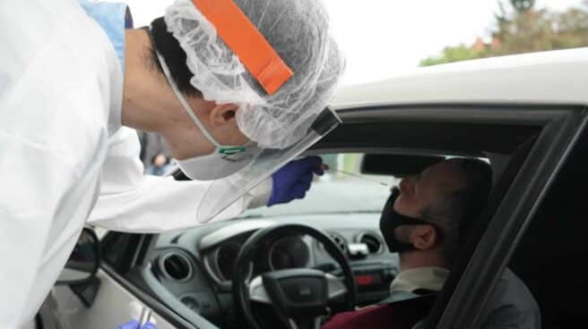 Un sanitario realiza una preuva del Covid-19 a un conductor.
