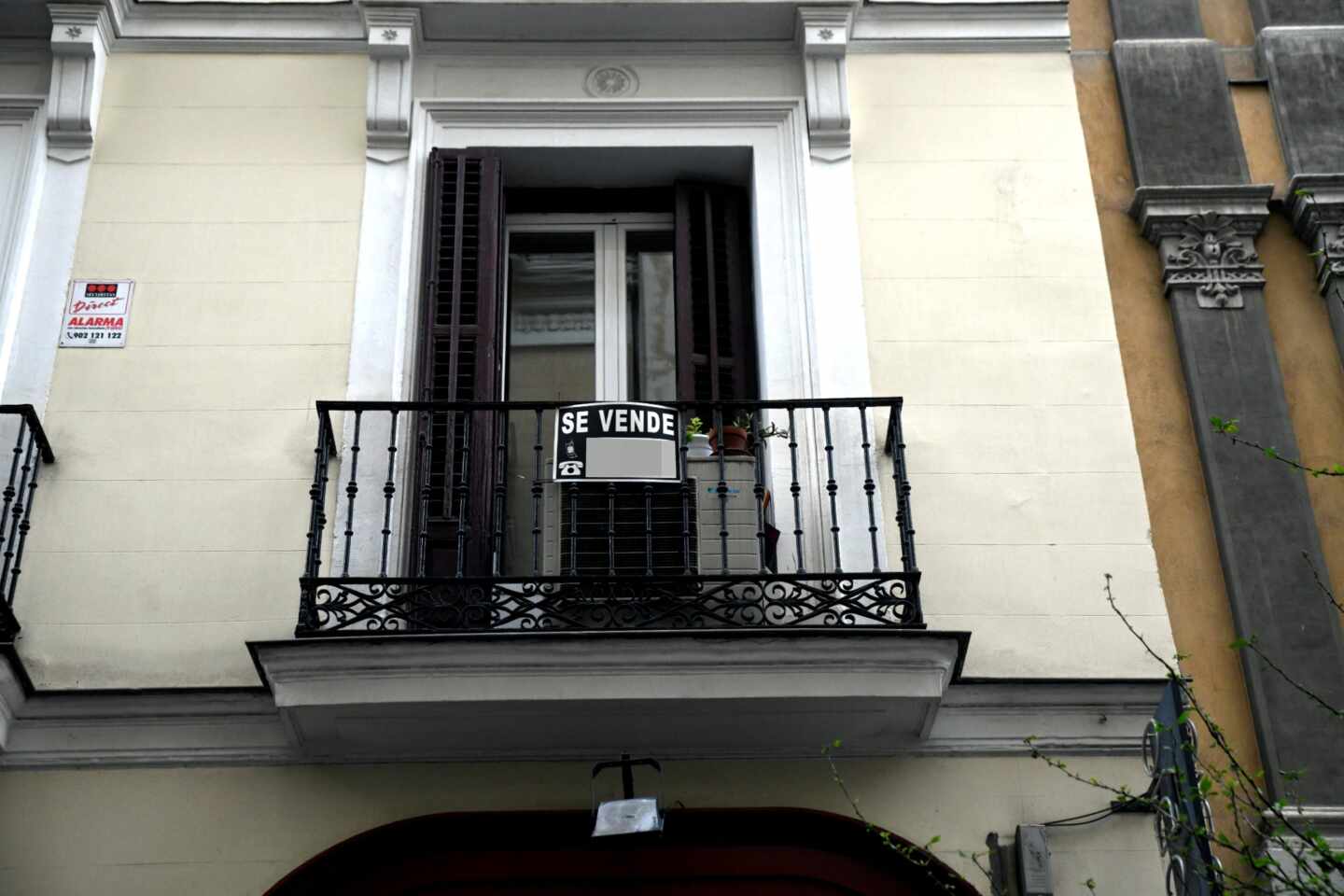 Un cartel de 'Se vende' cuelga del balcón de una vivienda.