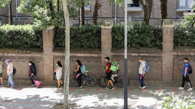 Dos riders hacen cola en Martínez Campos para conseguir una bolsa de comida Dos riders hacen cola en Martínez Campos para conseguir una bolsa de comida