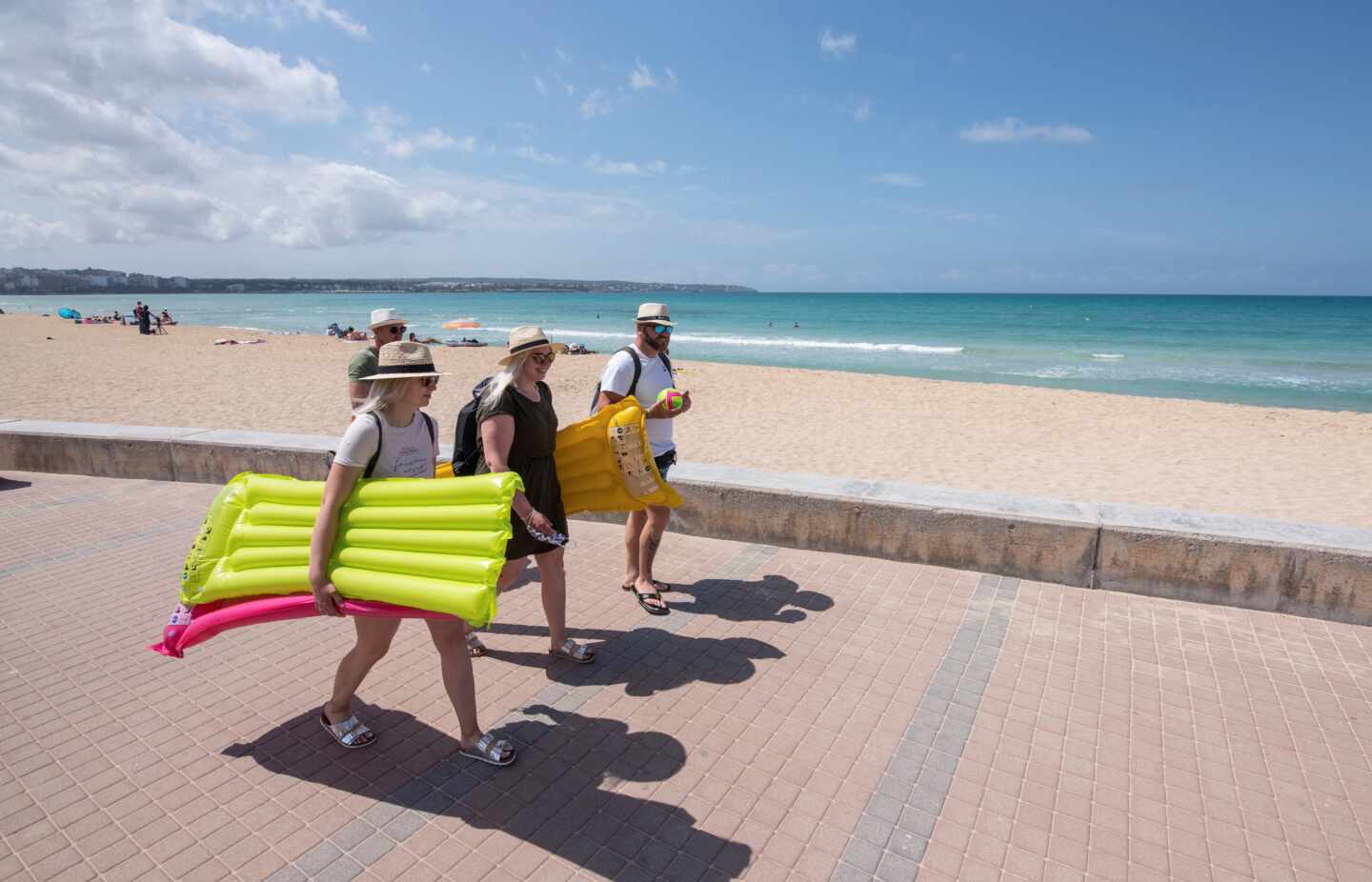 Turistas caminan por el paseo de la playa en Palma de Mallorca.