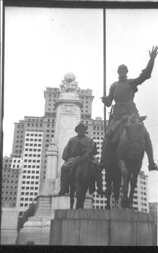 Fotografía de las estatuas del Quijote y Sancho Panza en la Plaza de España con el Edificio España detrás